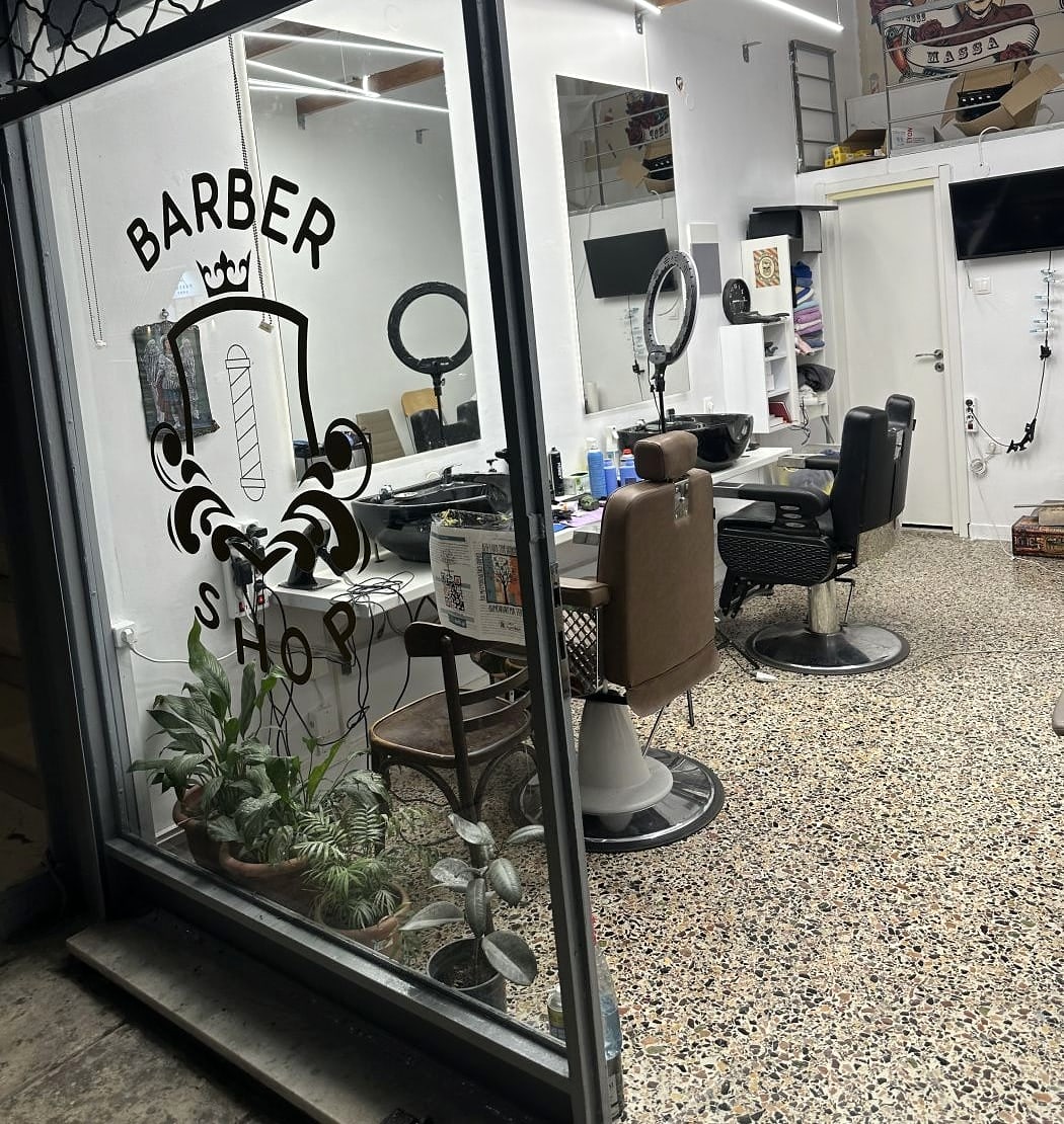 Η βιτρίνα του Massa Barber Shop στην Αναλήψεως 8, με το σήμα BARBER SHOP στο τζάμι και το φωτεινό εσωτερικό